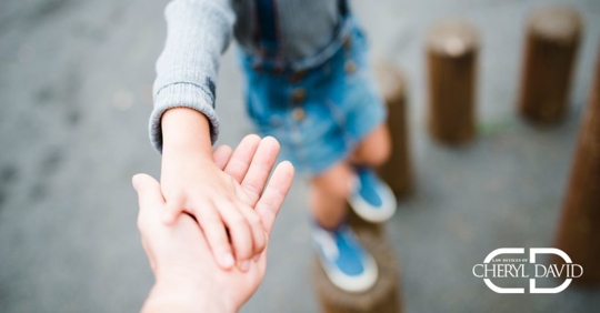 a child with holding hands with a guardian