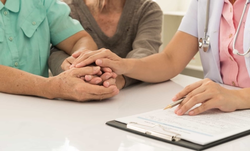 Doctor consoling patient over paperwork