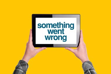 A tablet displays the error message "something went wrong" held by two hands.