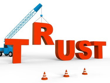 A graphic shows the word "TRUST" being constructed by a crane with orange blocks.